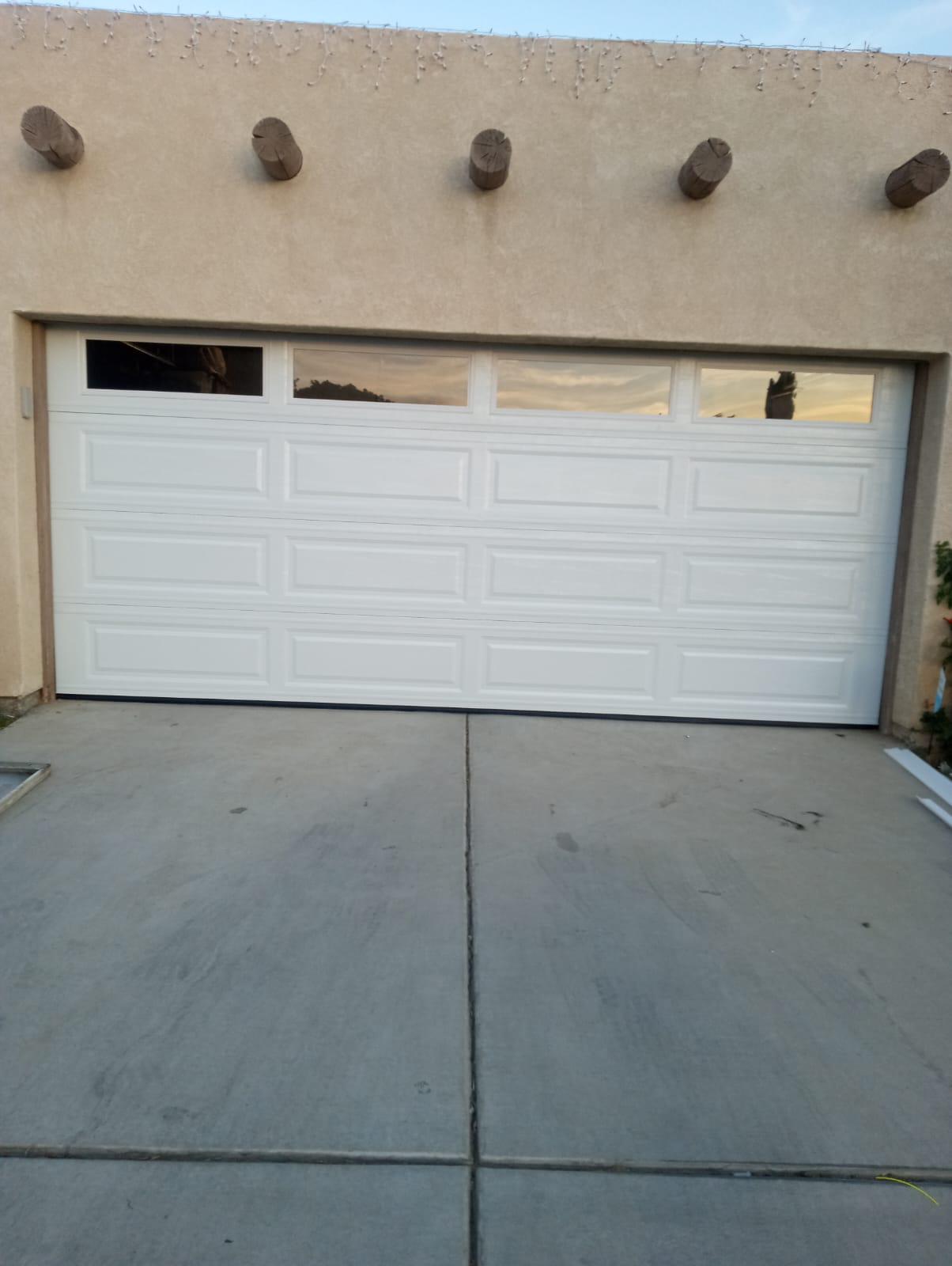 White garage door with glass-top windows on an adobe-style home in La Quinta