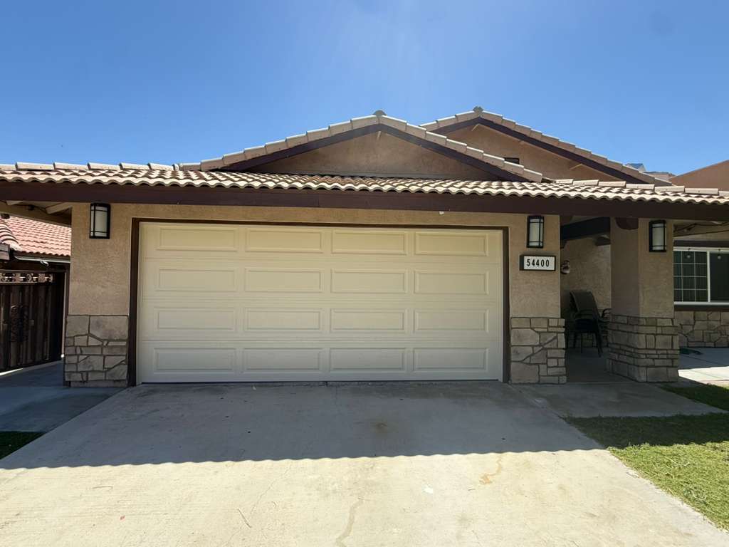 Cream long-panel garage door with stone-accent surround in Bermuda Dunes